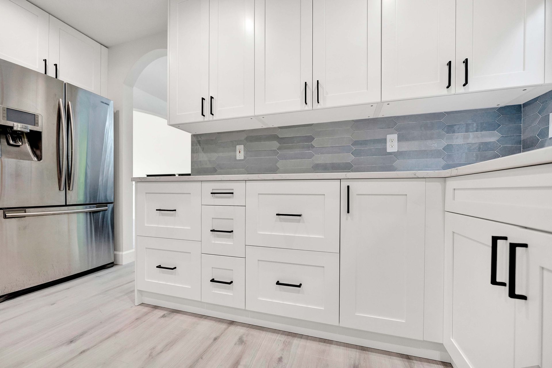 A kitchen with white cabinets and stainless steel appliances.
