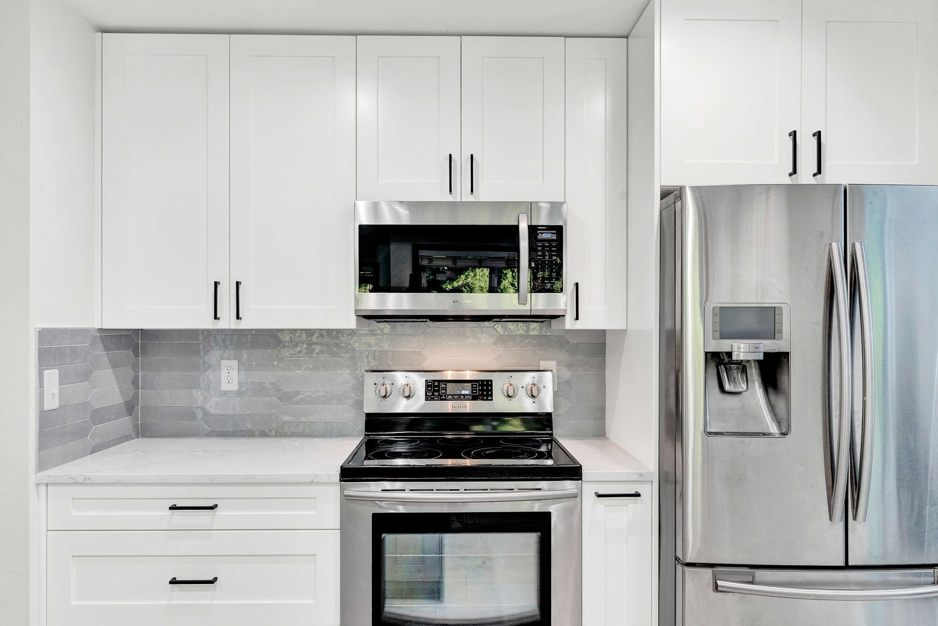 A kitchen with stainless steel appliances and white cabinets.