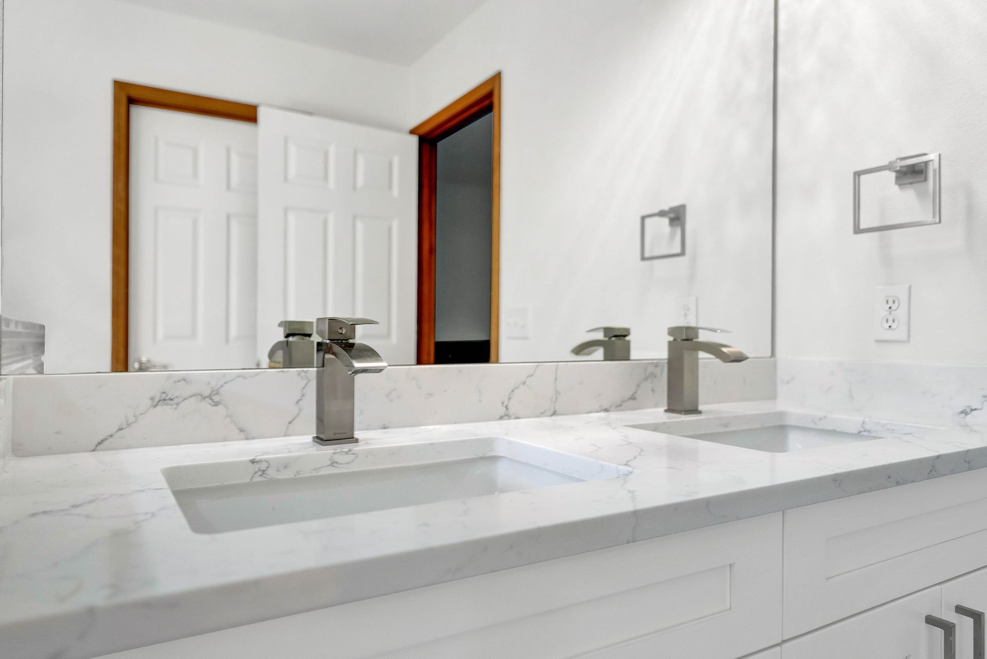 A bathroom with two sinks and a large mirror.
