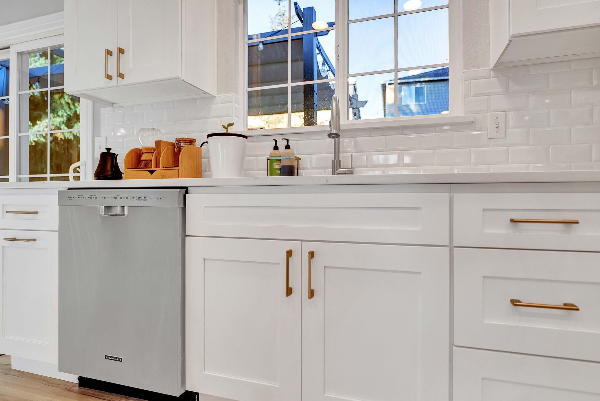 A kitchen with white cabinets and a stainless steel dishwasher.
