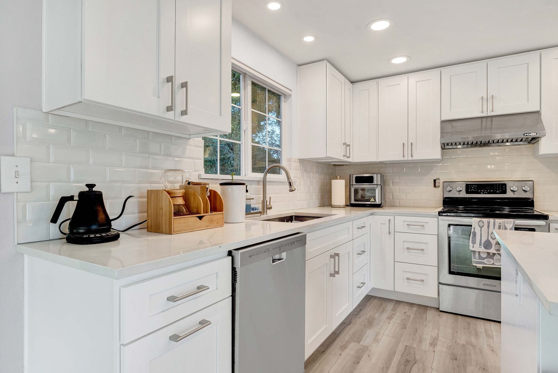 A kitchen with white cabinets and stainless steel appliances.