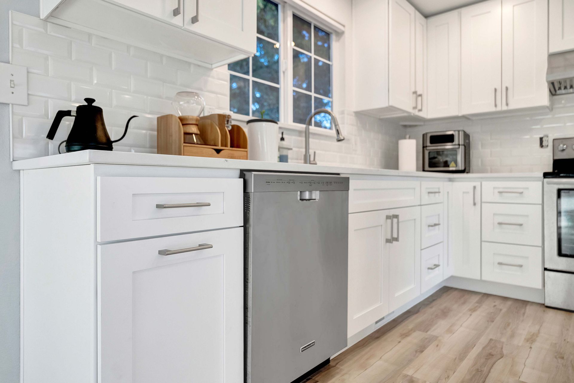 A kitchen with white cabinets and a stainless steel dishwasher.