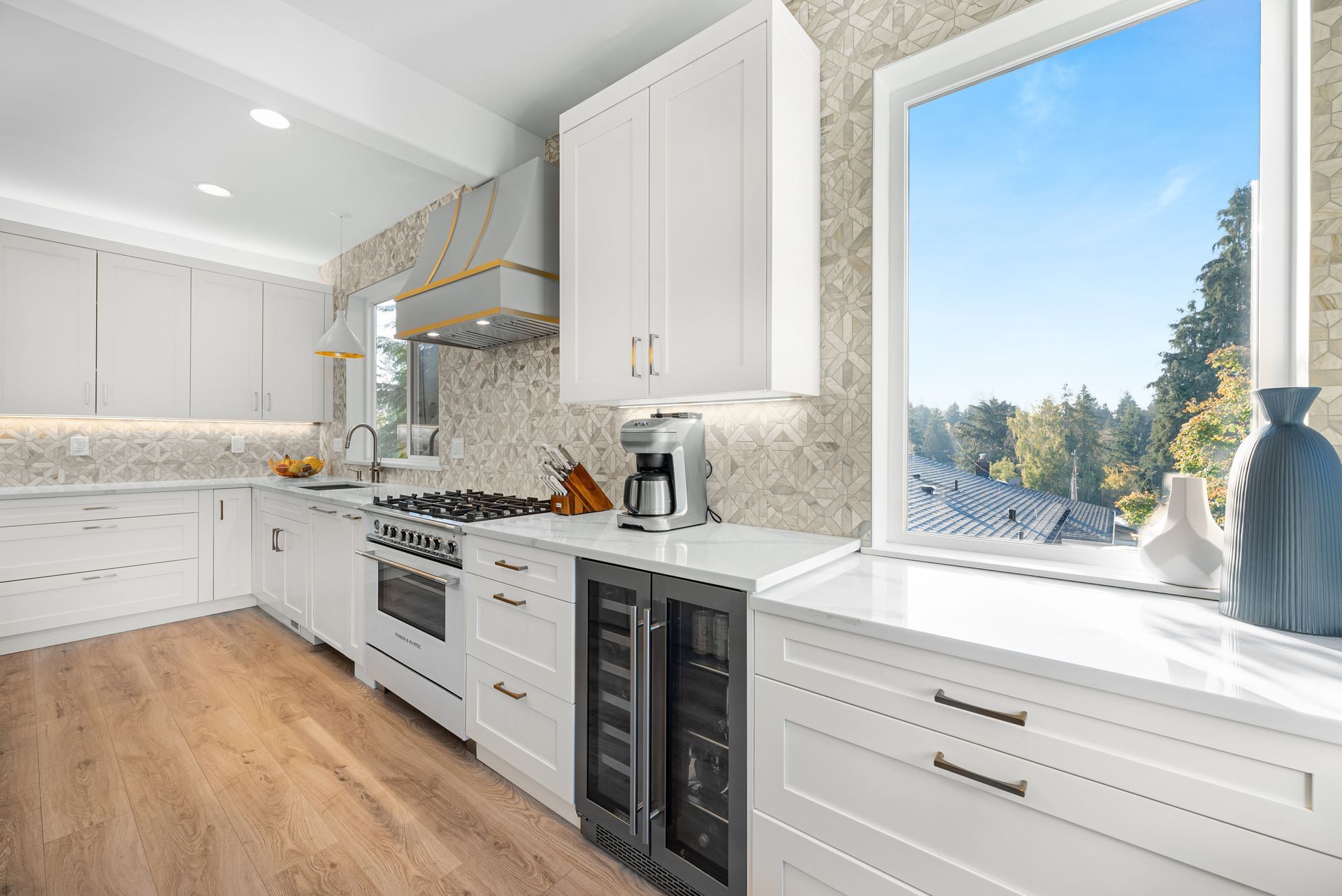 A kitchen with white cabinets , a stove , a refrigerator and a window.