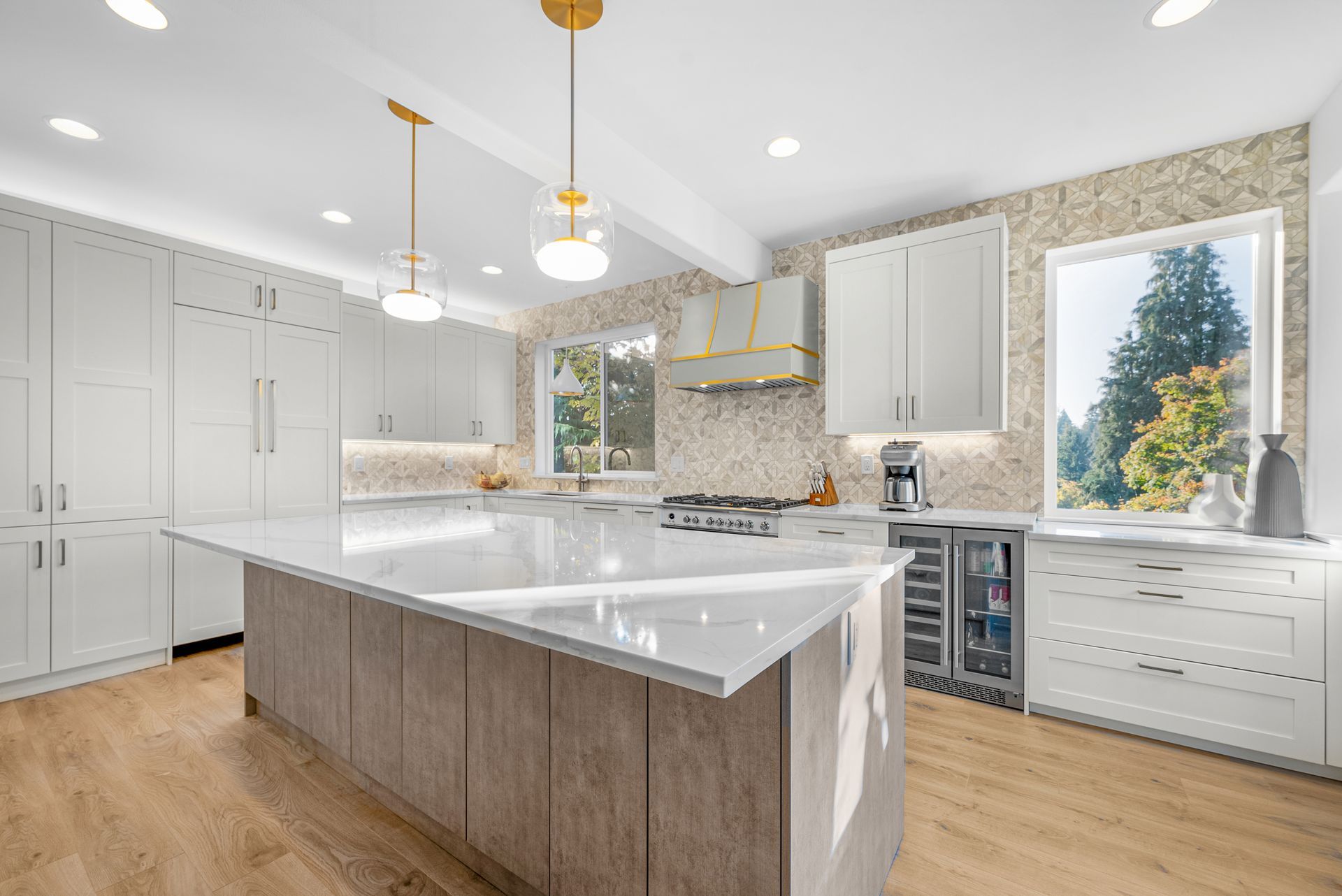 A kitchen with white cabinets and a large island in the middle.
