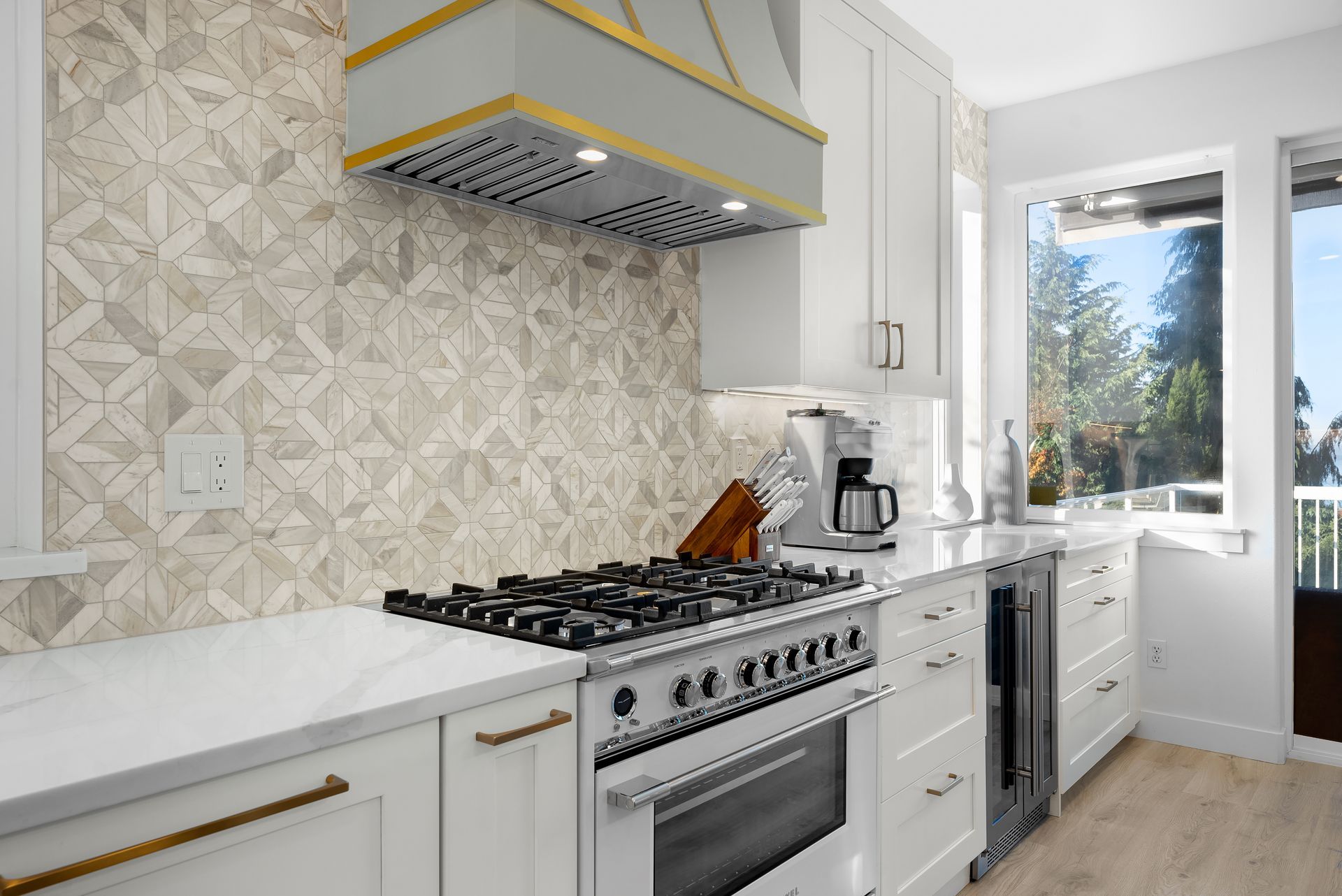 A kitchen with white cabinets and a stove top oven.