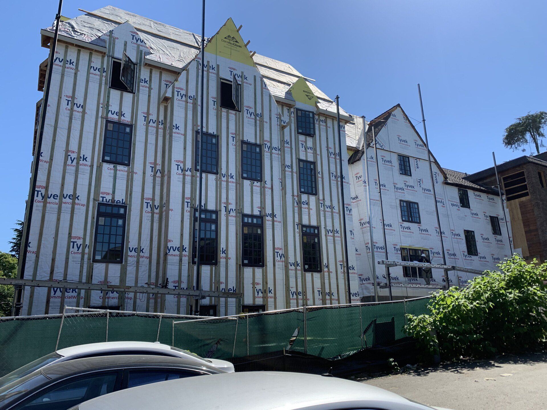 A building under construction with a car parked in front of it