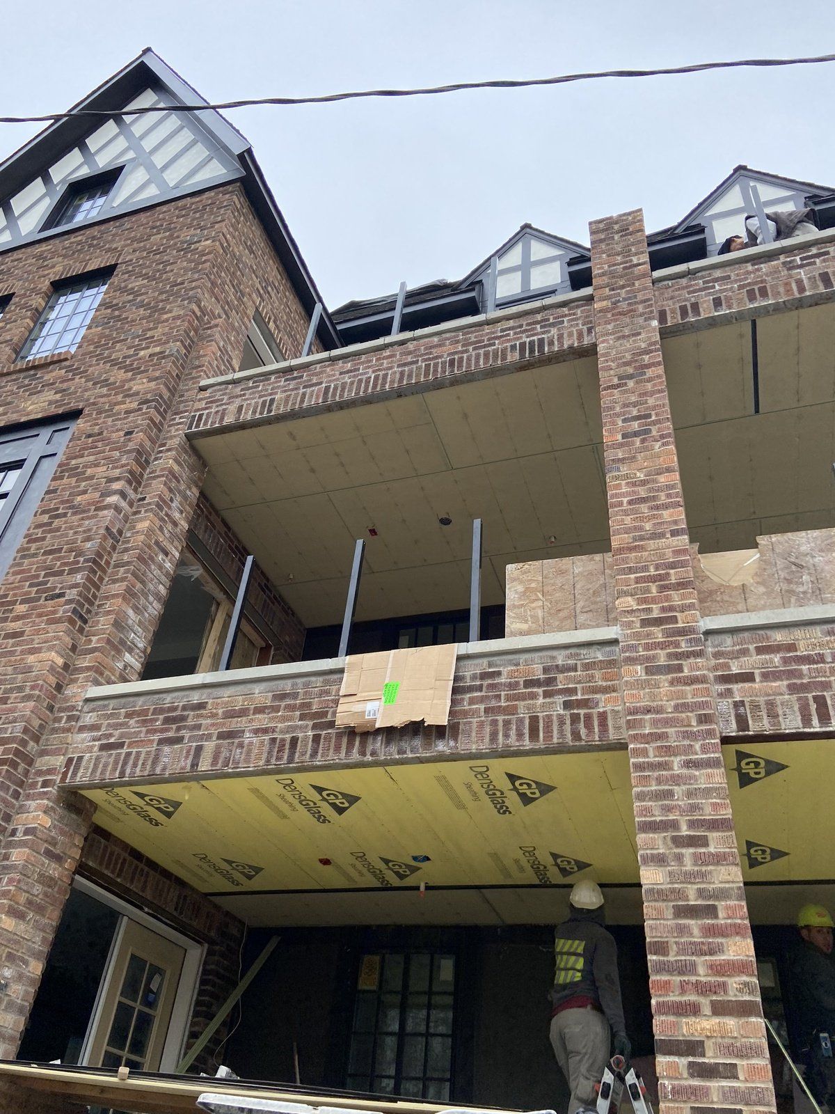 A large brick building with a balcony under construction
