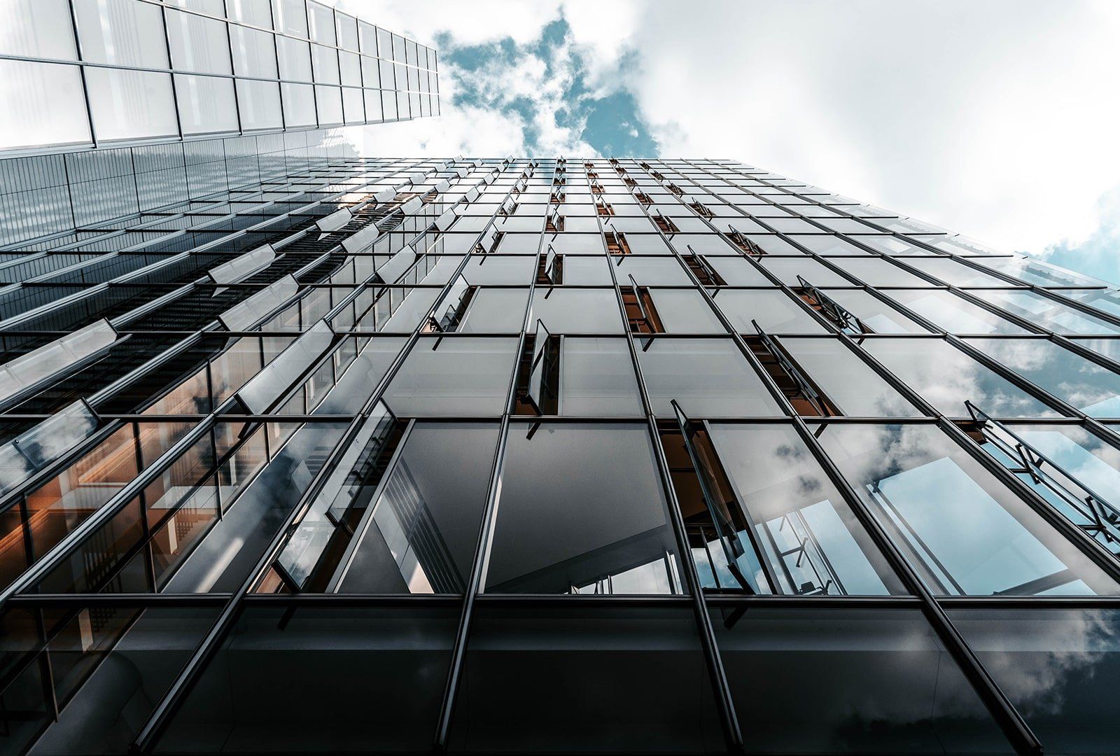 Modern commercial building Looking up at a tall building with a lot of windows.