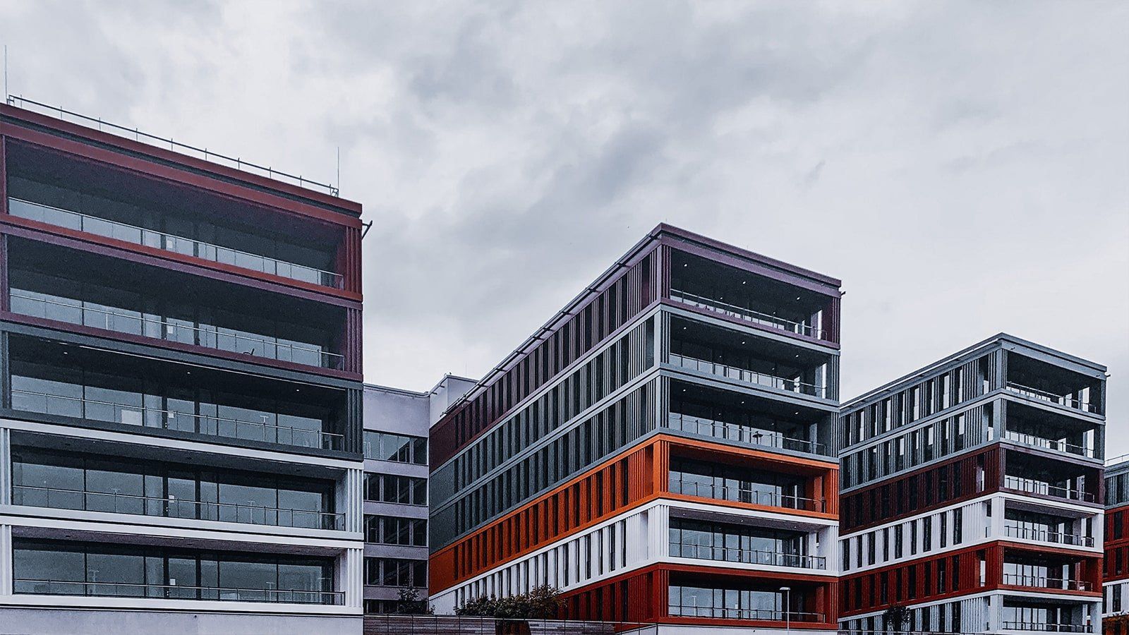 Modern commercial building A row of tall buildings with a cloudy sky in the background.