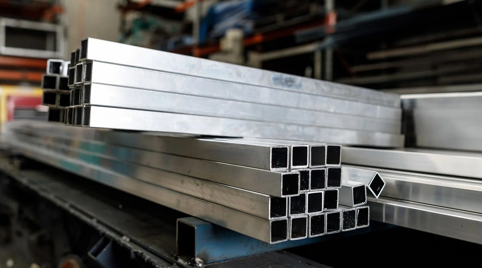 Recycled steel A stack of aluminum tubes are stacked on top of each other in a warehouse.