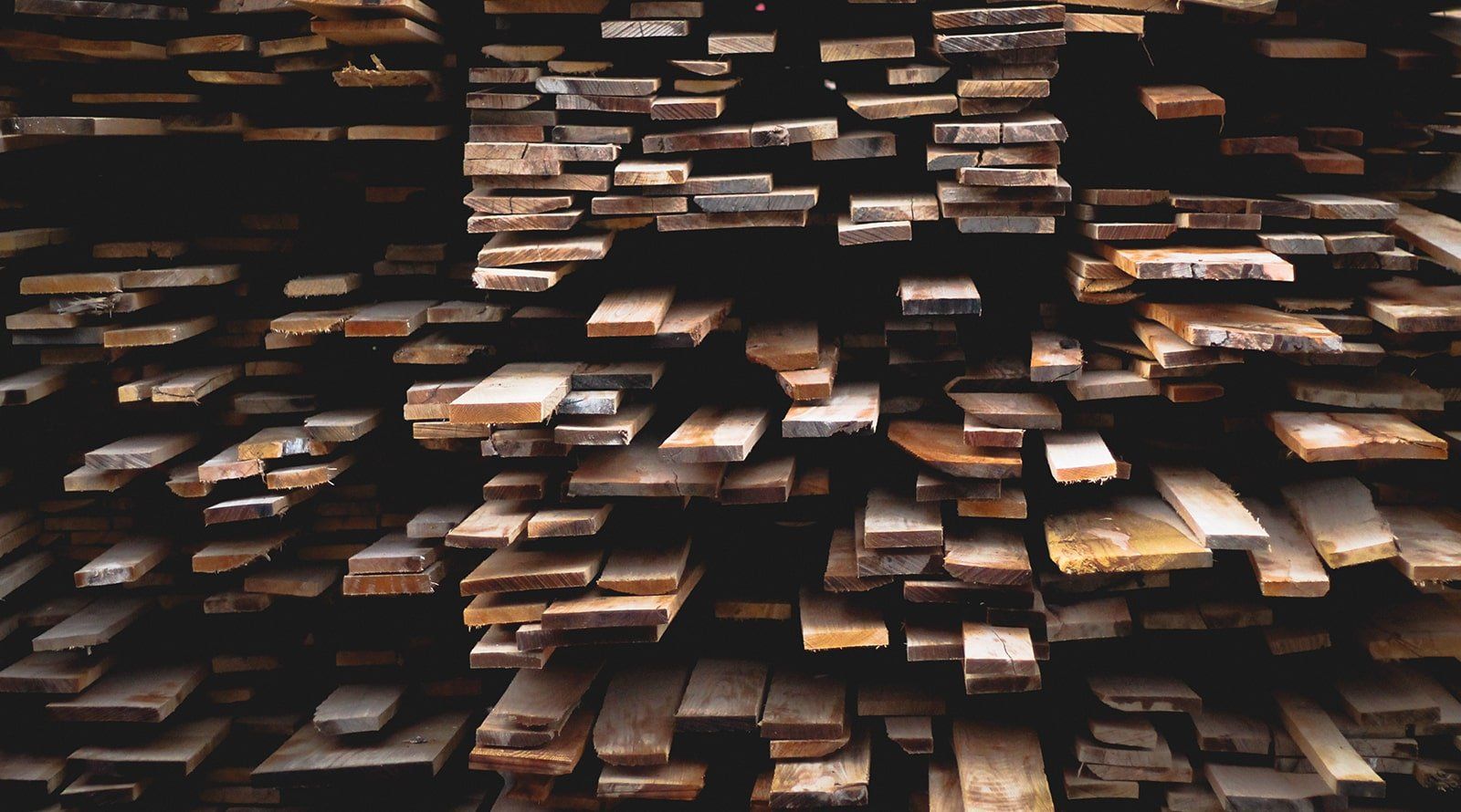 Reclaimed wood materials A pile of wood stacked on top of each other