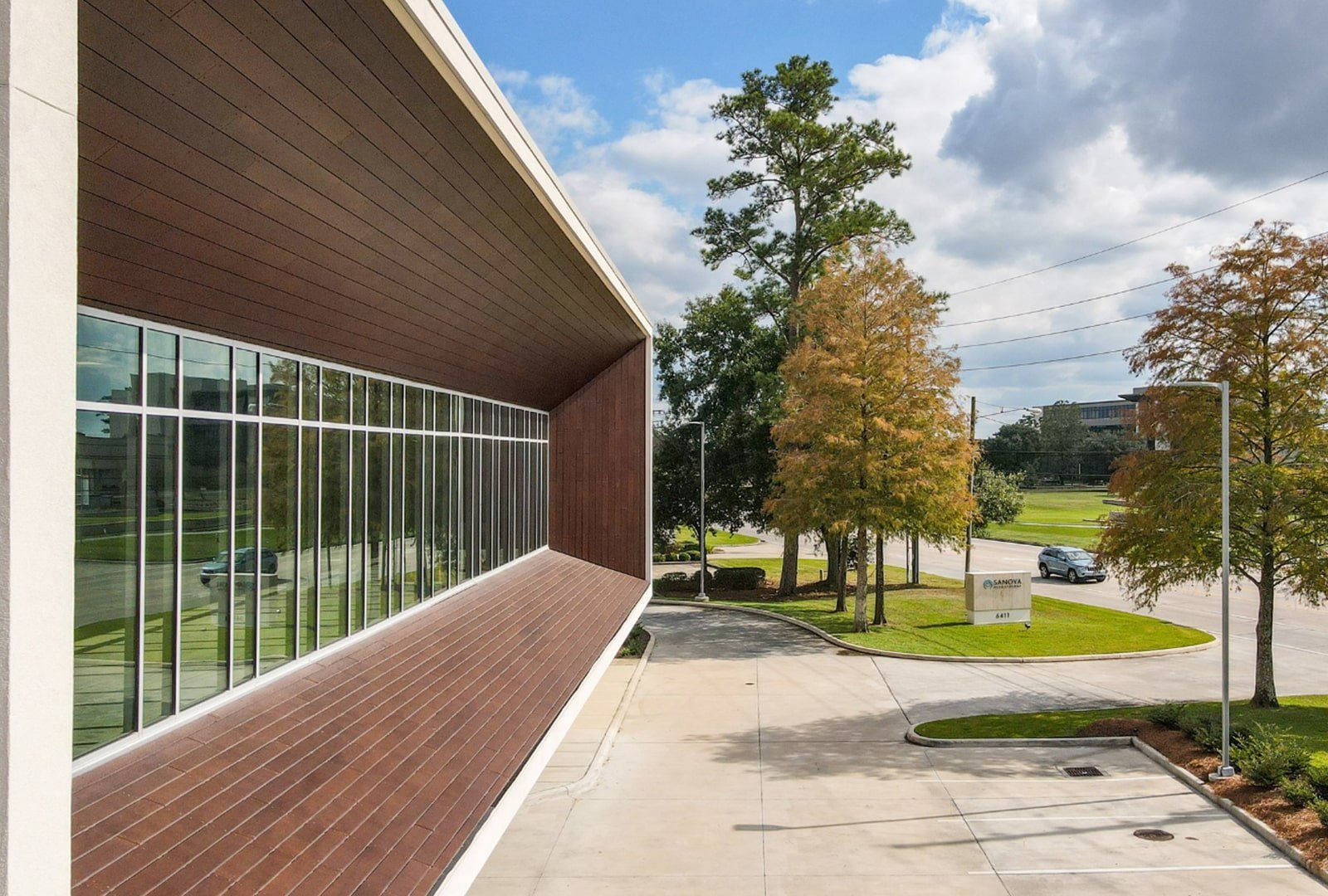 Commercial structure made of wood A building with a lot of windows and trees in the background