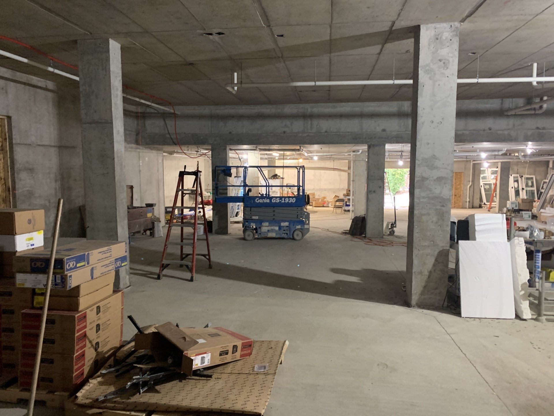 A large room with a lot of boxes and a ladder in it.