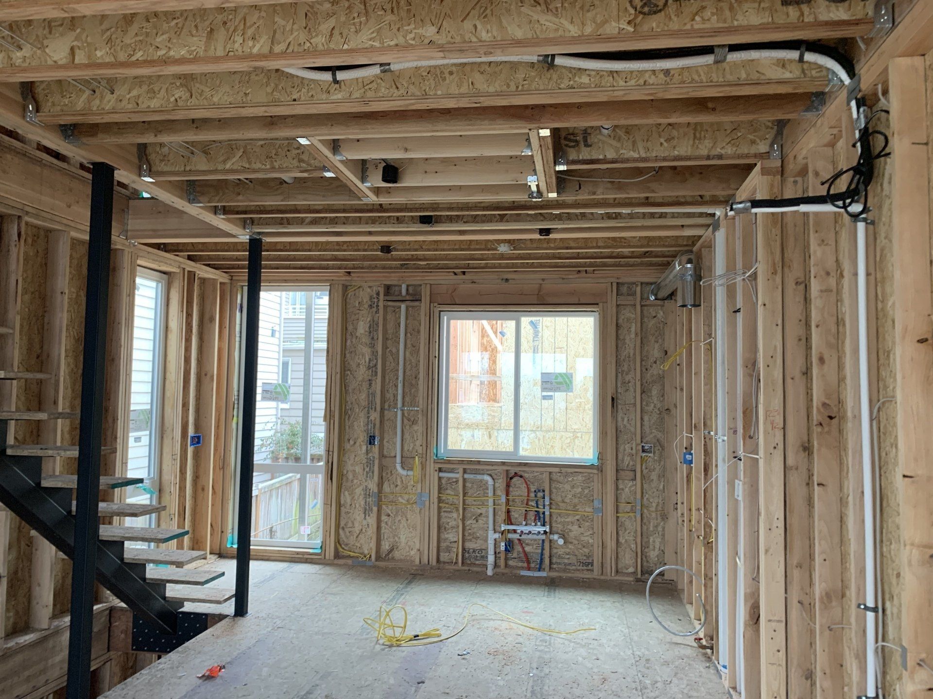 A room in a house under construction with a staircase.