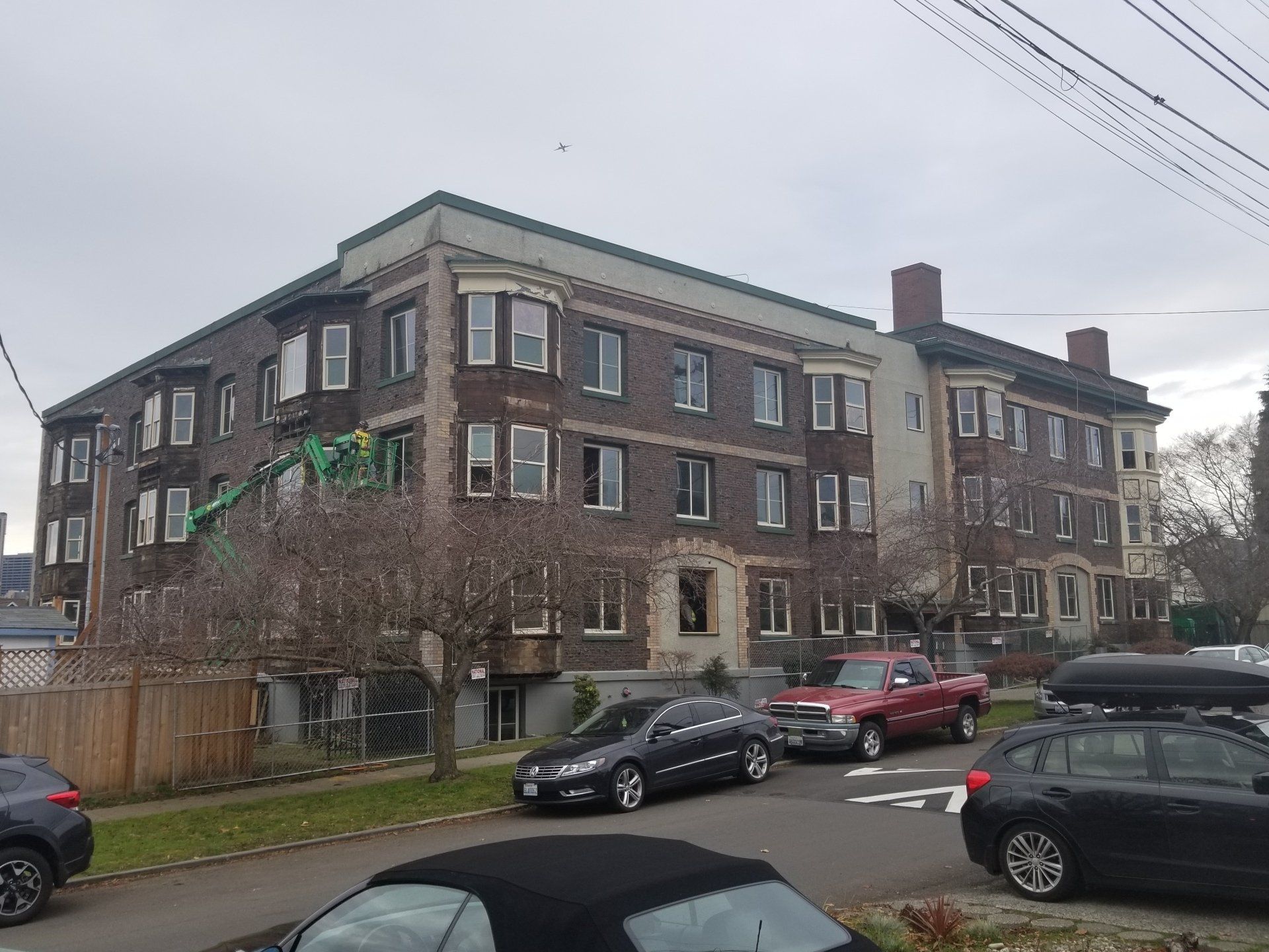A large brick building with cars parked in front of it.