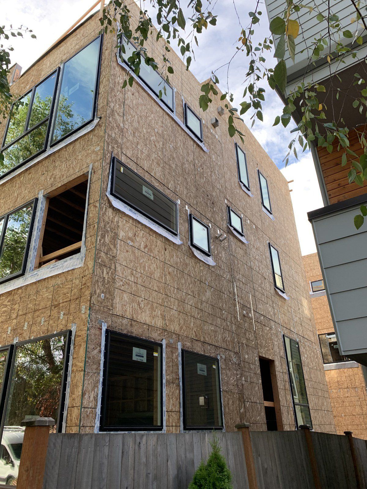 A building under construction with a lot of windows and a fence in front of it.