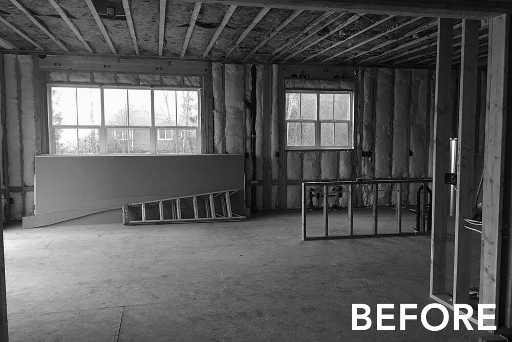 A black and white photo of a room in a house under construction.