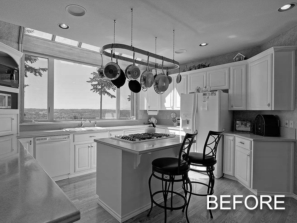 A before picture of a kitchen with white cabinets and black chairs