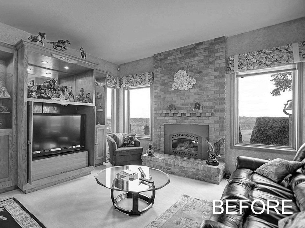 A black and white photo of a living room with a fireplace and a couch.