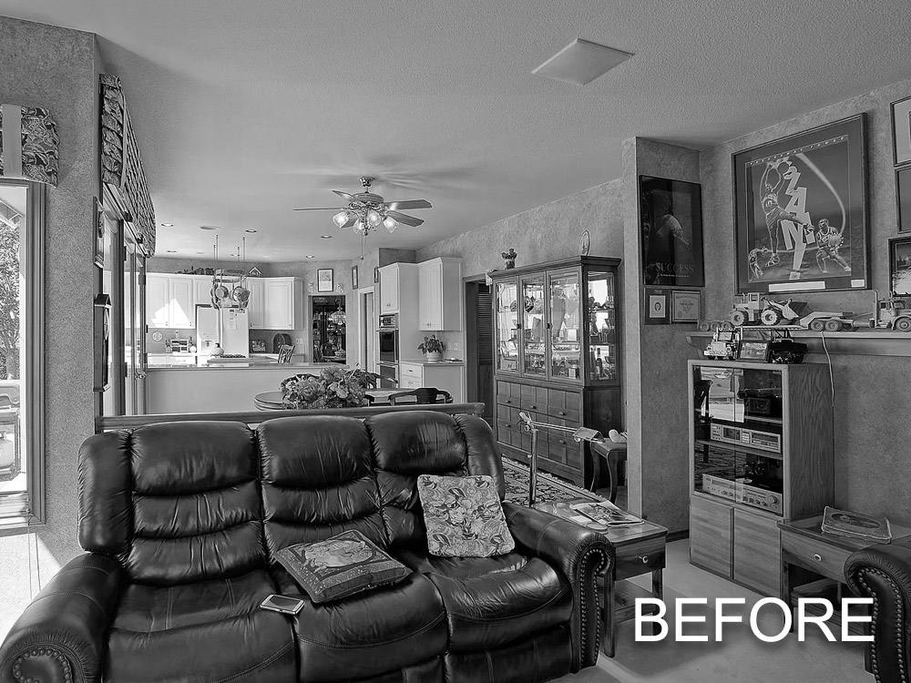 A black and white photo of a living room before a remodel