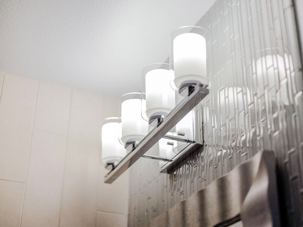 A bathroom with a wall light and a mirror.