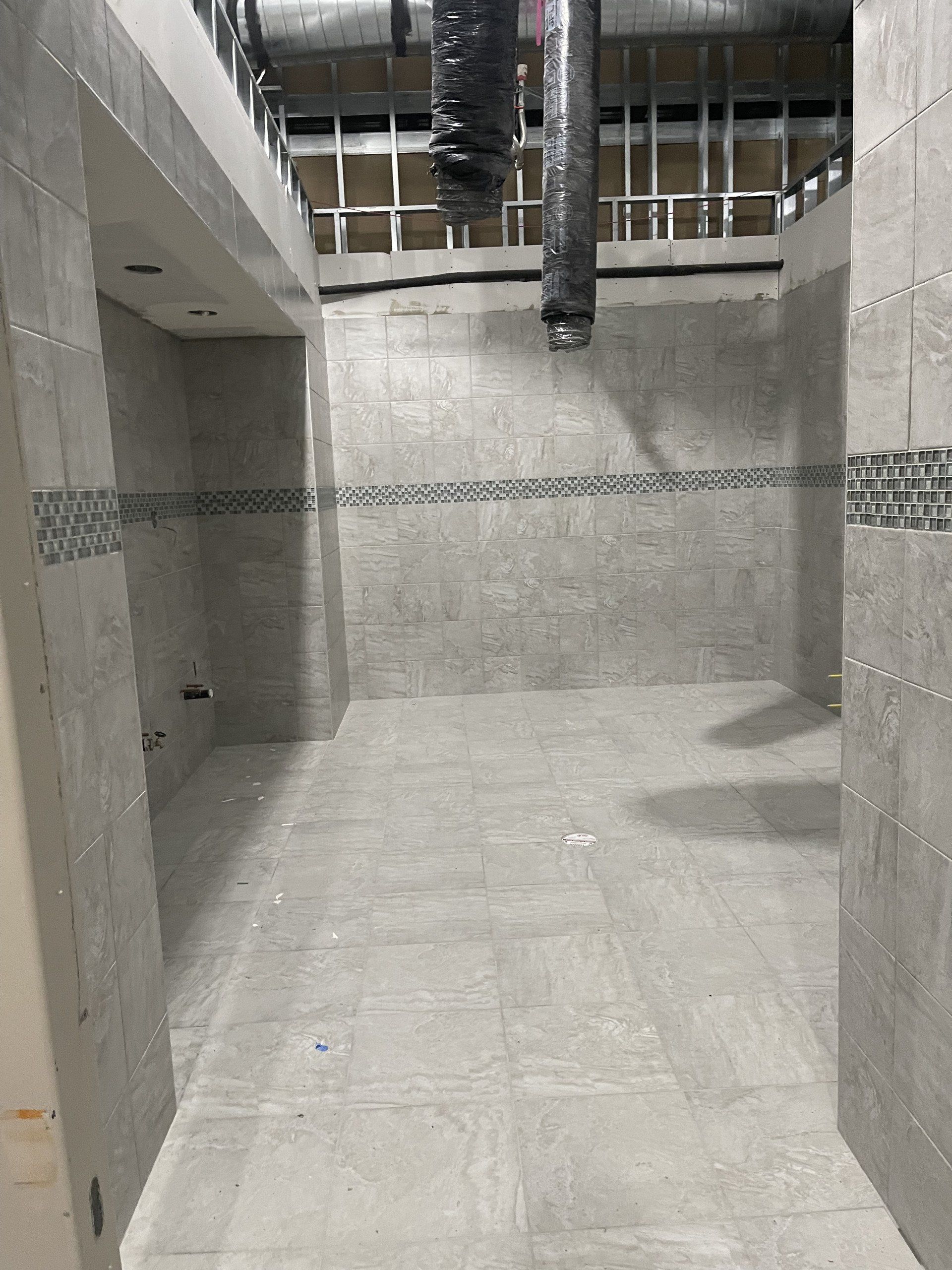 A bathroom under construction with tile floors and walls.