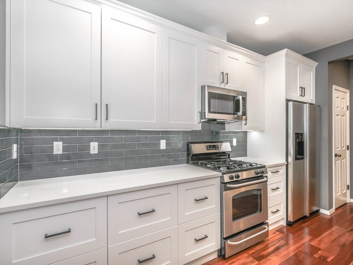 A kitchen with white cabinets and stainless steel appliances.