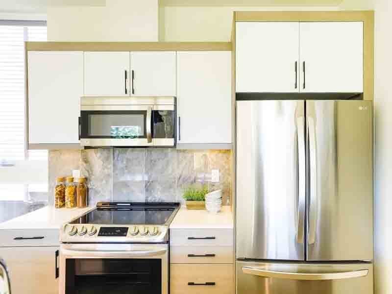 A kitchen with stainless steel appliances and white cabinets.