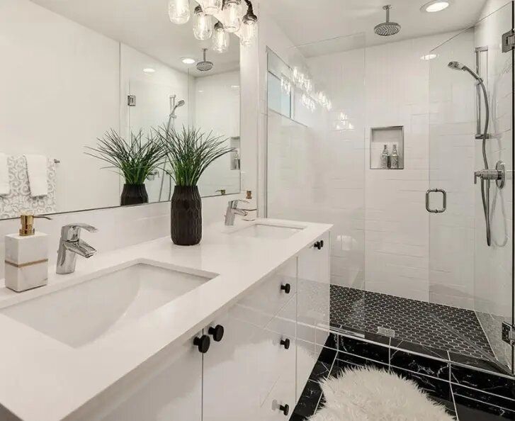 A bathroom with a sink , mirror , and walk in shower.