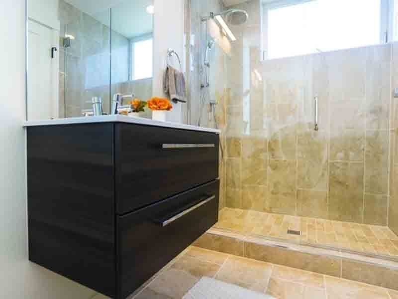 A bathroom with a sink and a walk in shower.