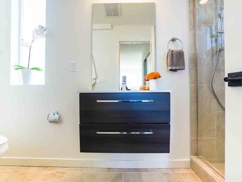 A bathroom with a sink , mirror and shower.