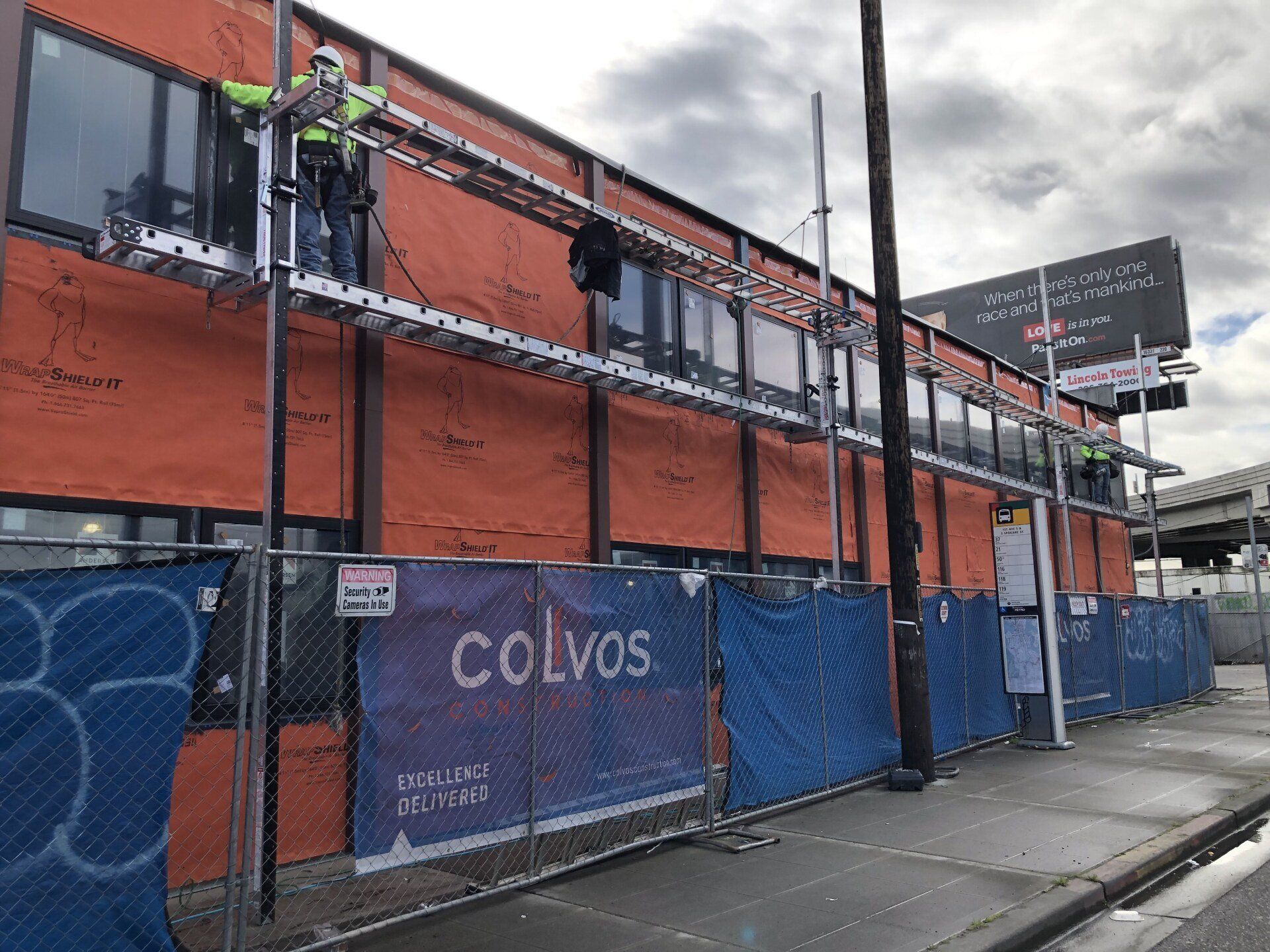 Construction workers are working on the side of a building.