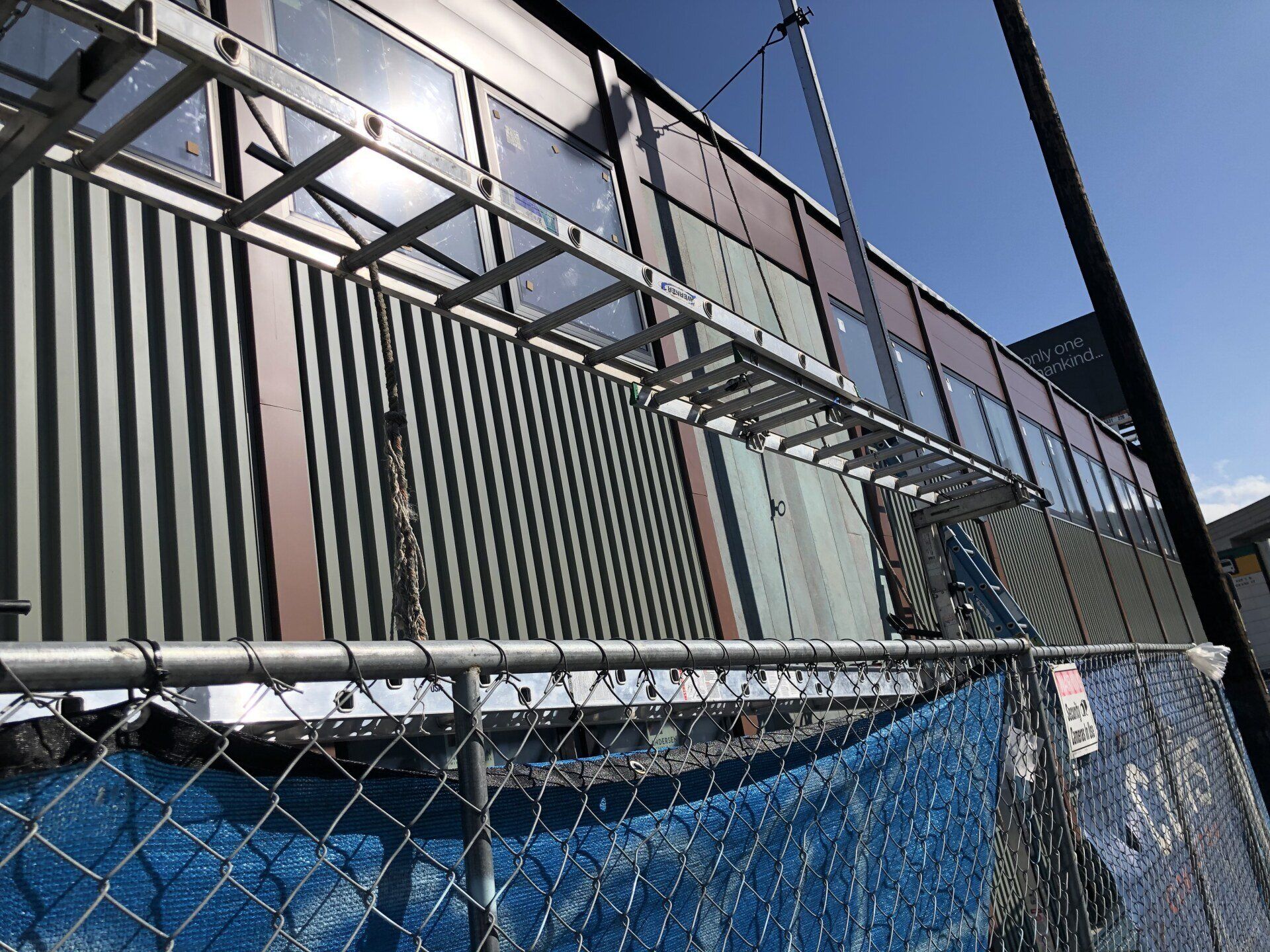 A chain link fence surrounds a building under construction.