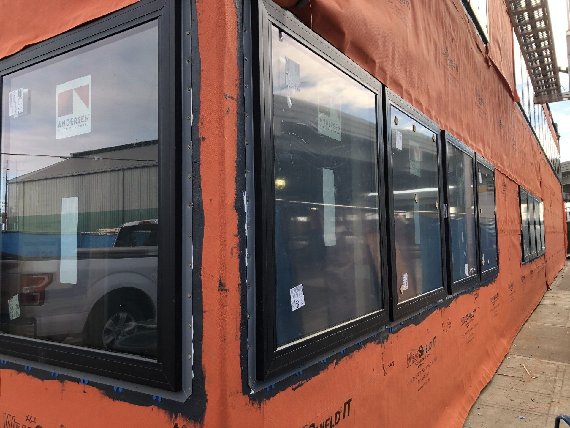 A building with a lot of windows and a truck parked in front of it.