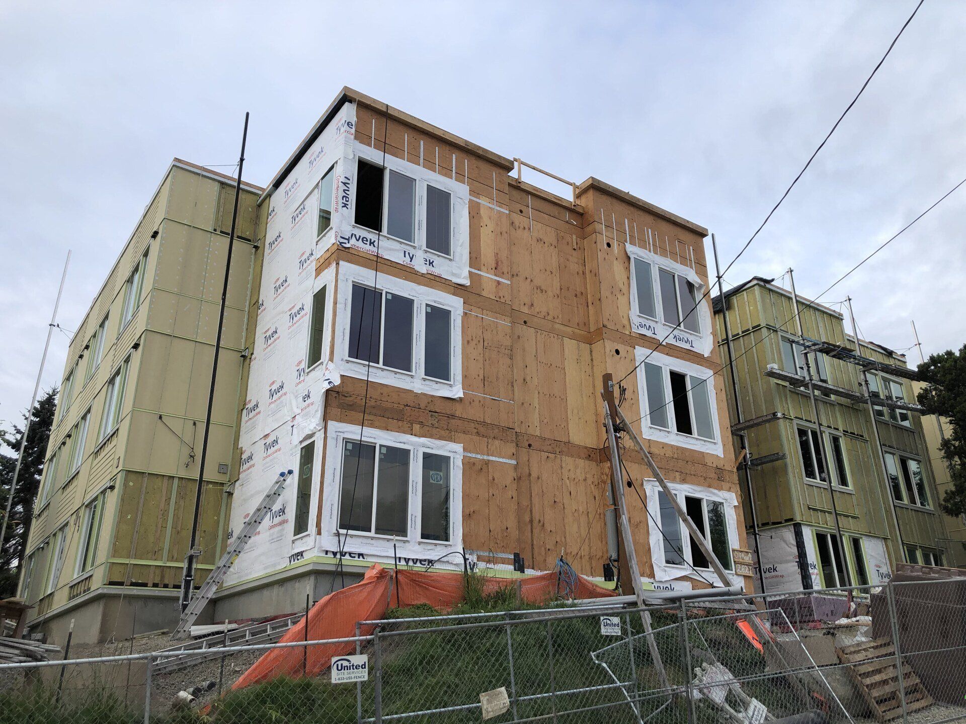 A large building under construction with a fence around it.