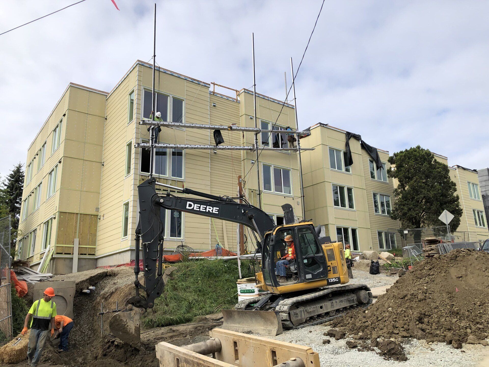 A construction site with a large building in the background and a bulldozer in front of it.