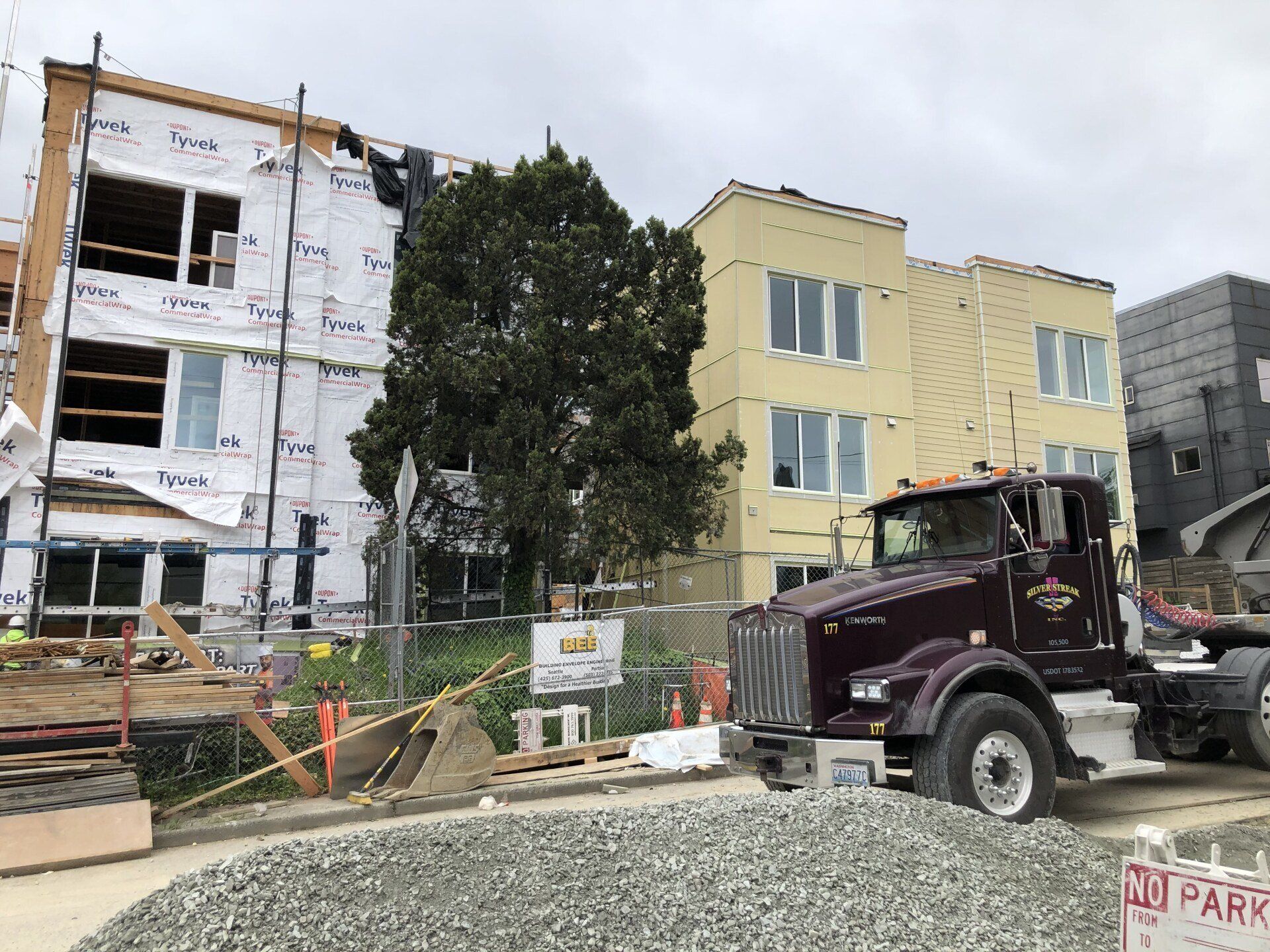 A truck is parked in front of a building under construction.