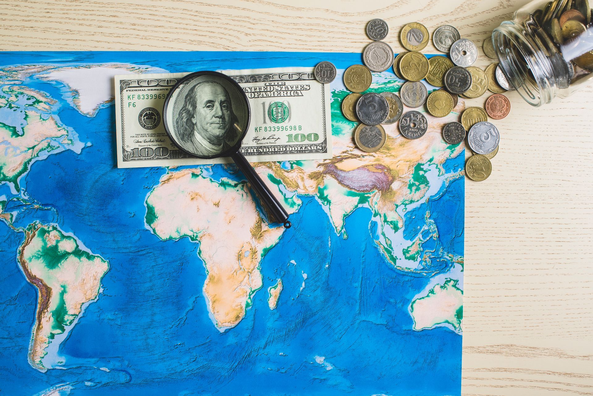 A magnifying glass is sitting on top of a map of the world.