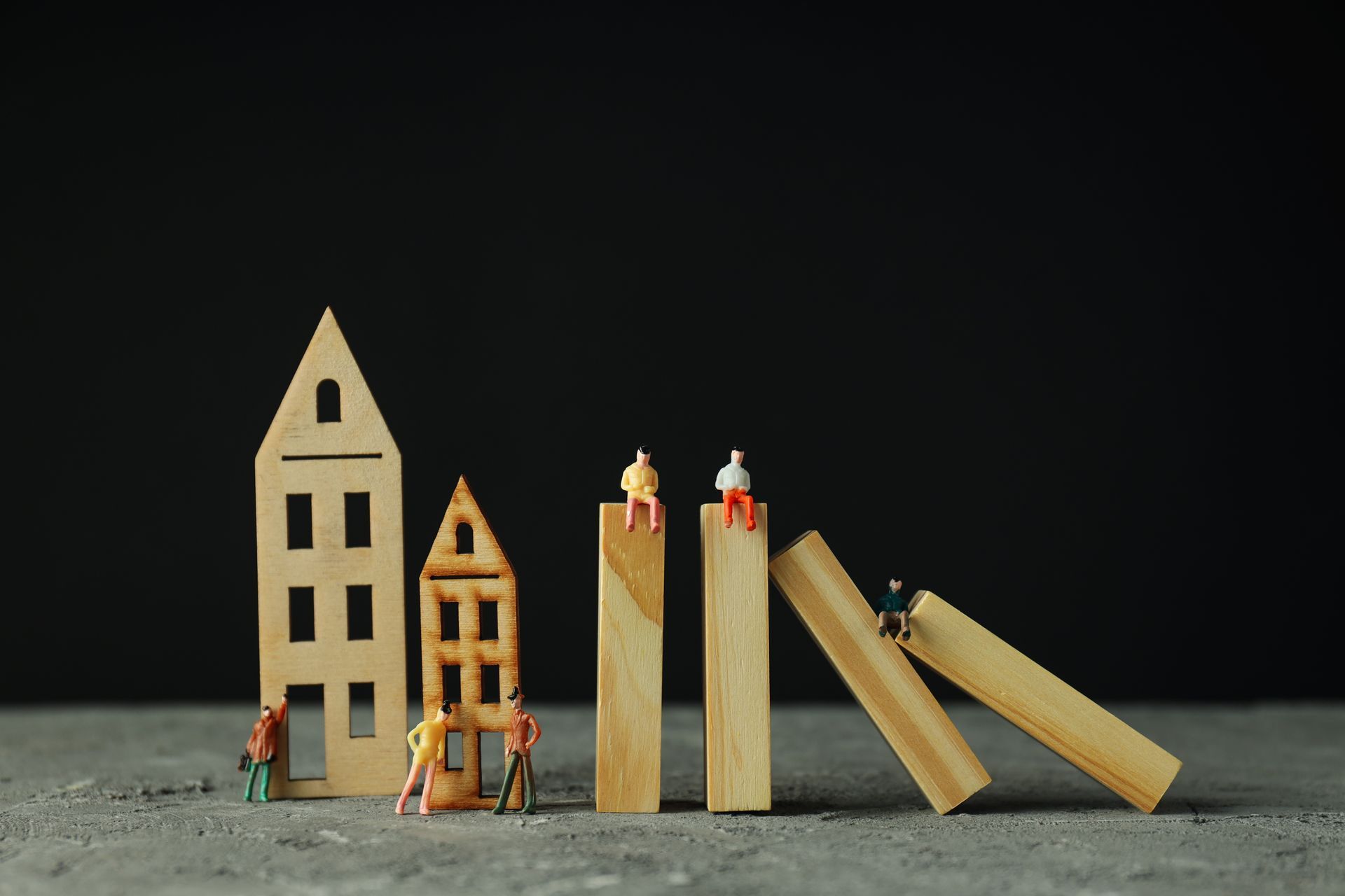 A group of miniature people standing on top of wooden blocks.