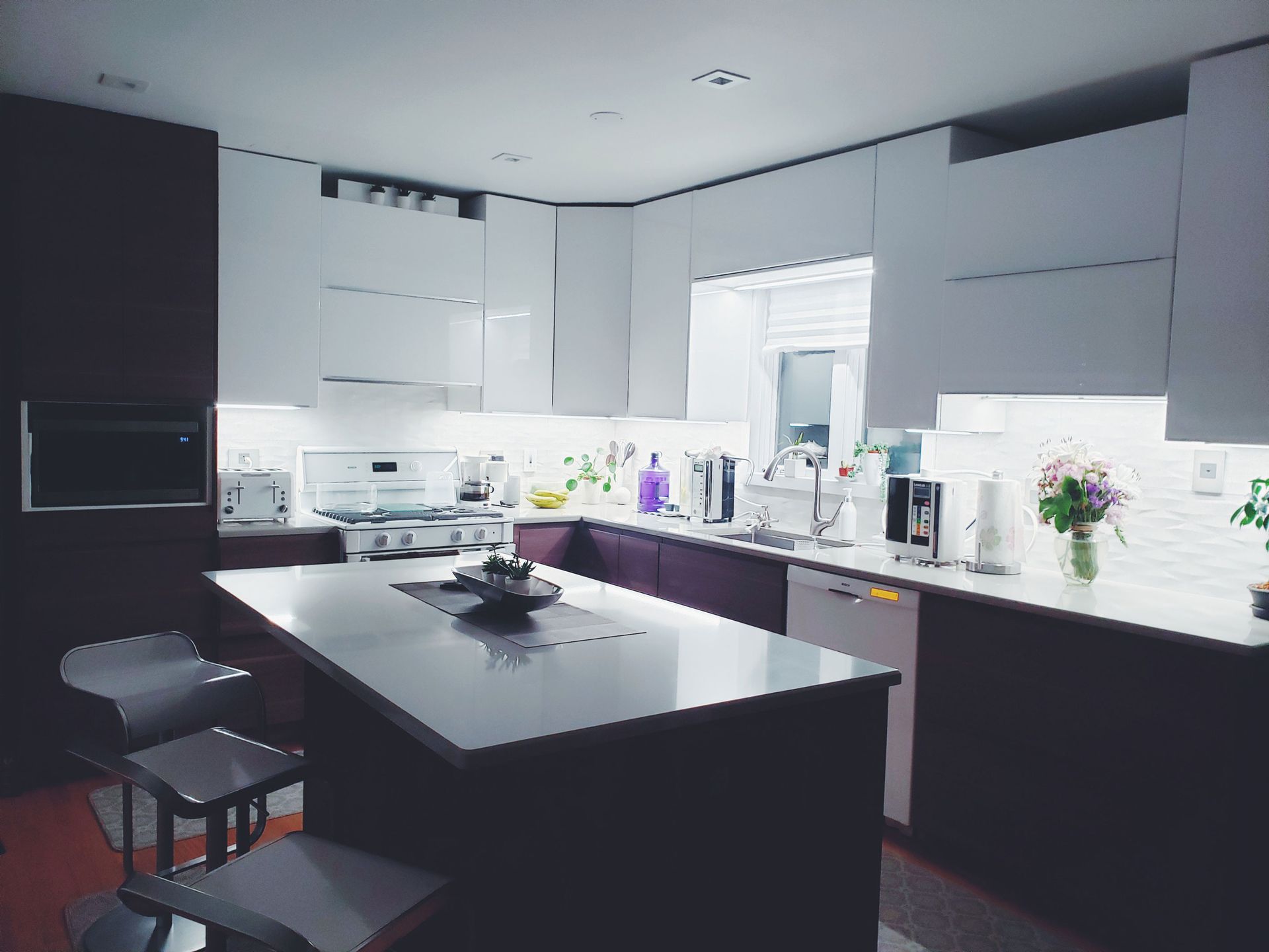 A kitchen with white cabinets and a large island in the middle.