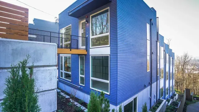 A blue building with a lot of windows and trees in front of it.