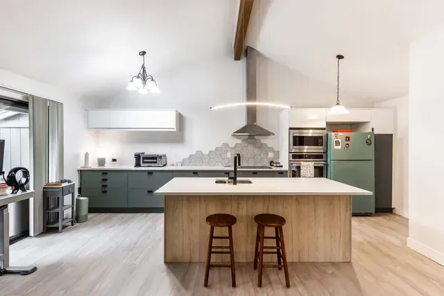 A kitchen with a large island and two stools