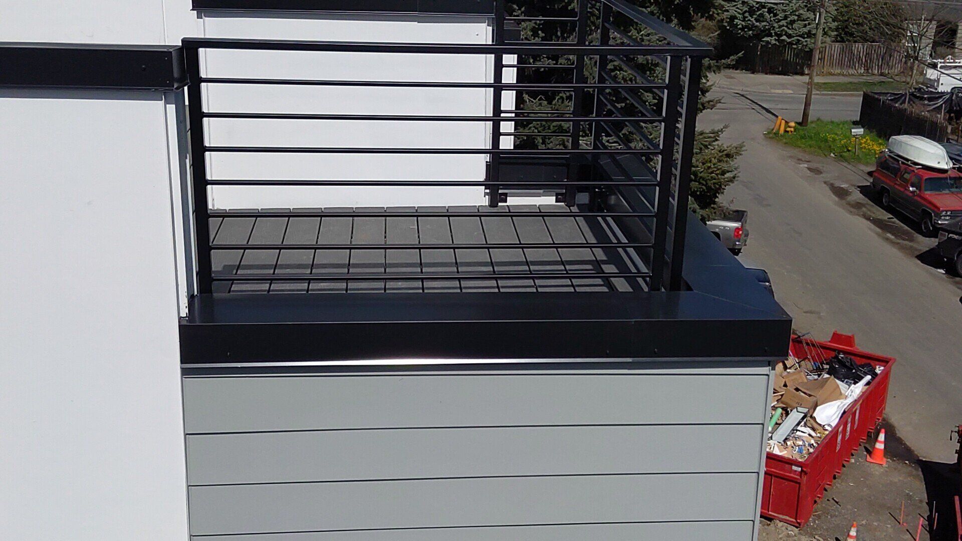 A balcony with a black railing on the side of a building.