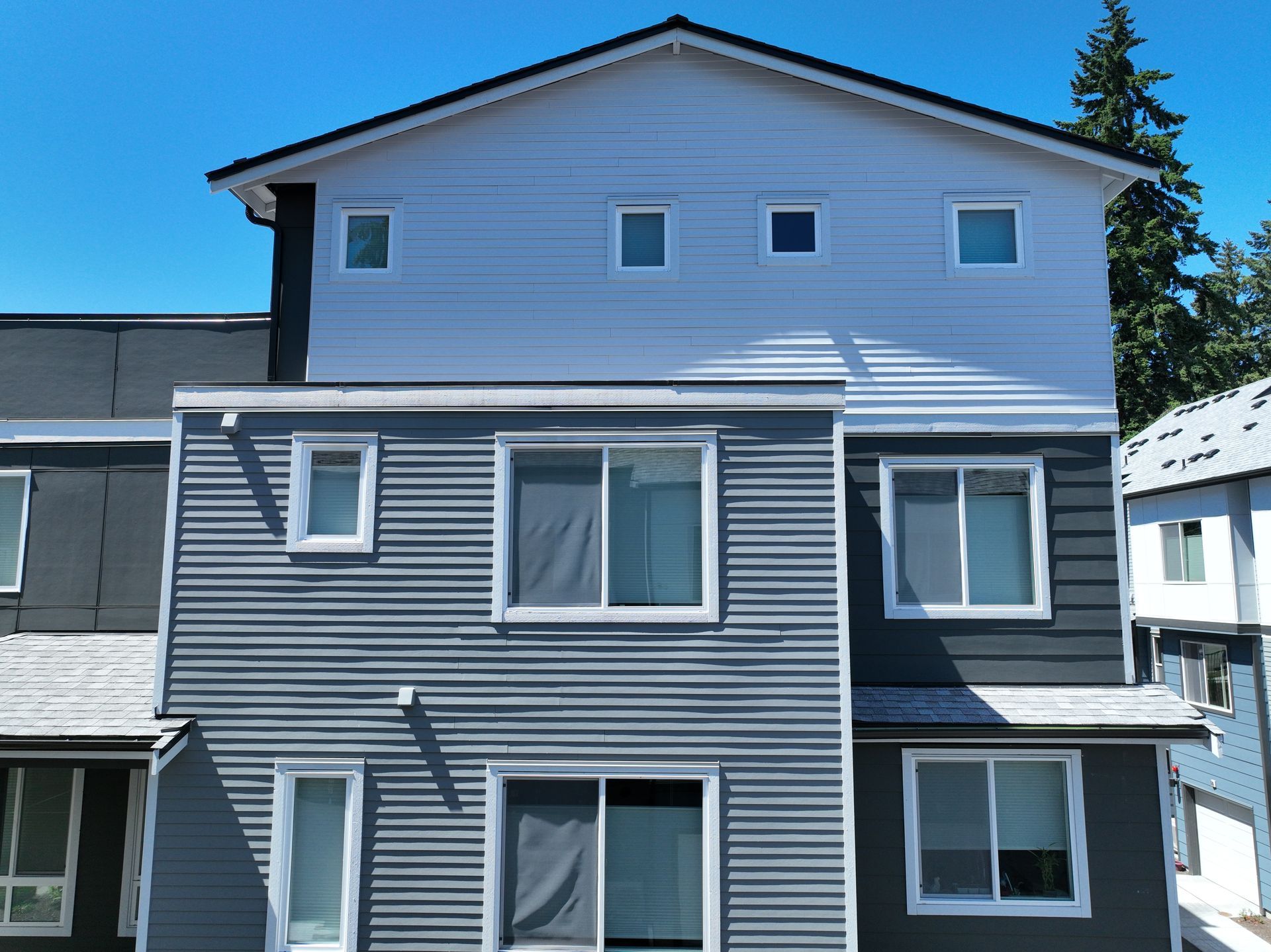 A gray and white house with a lot of windows