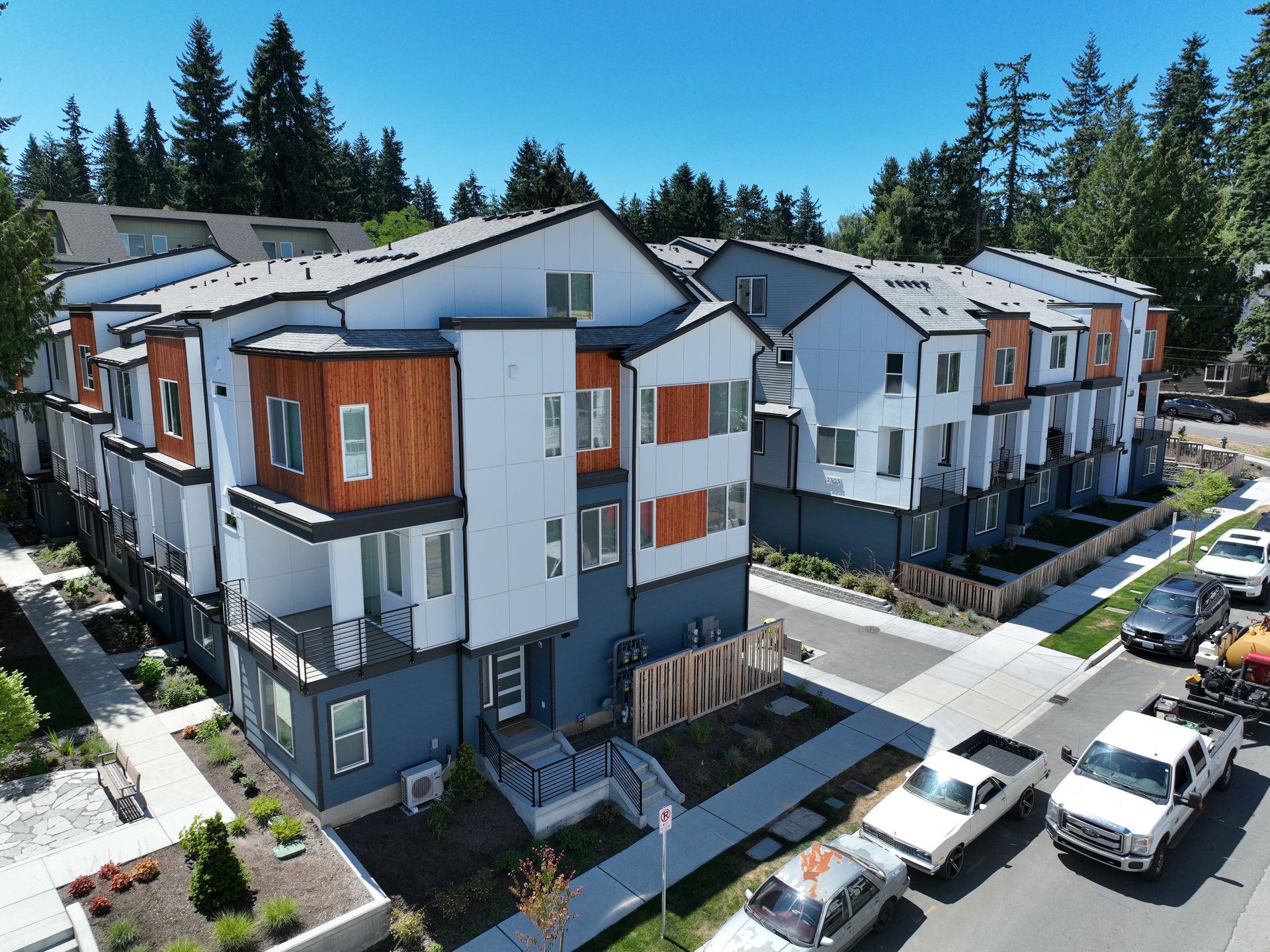 An aerial view of a large apartment building with cars parked in front of it