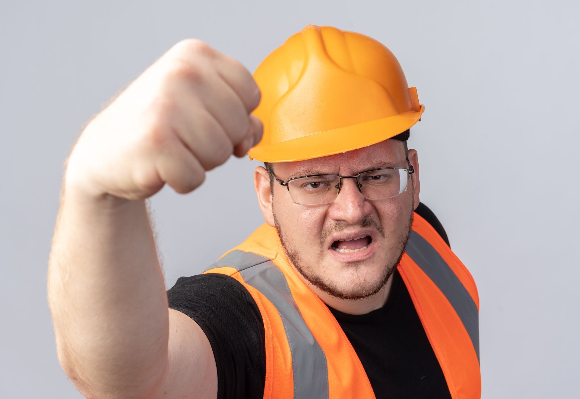 A construction worker wearing a hard hat and safety vest is making a funny face.