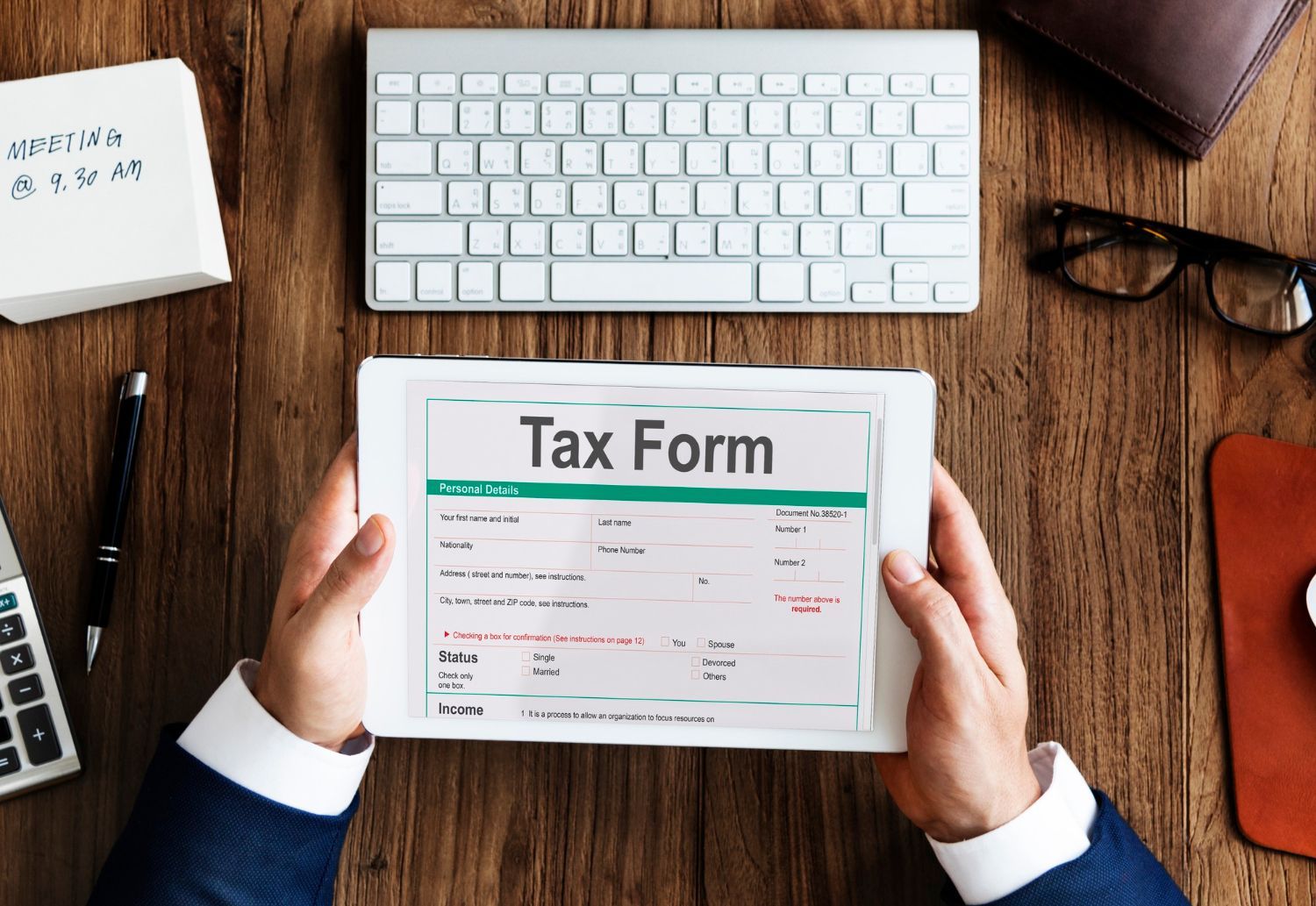 A person is holding a tablet with a tax form on it.
