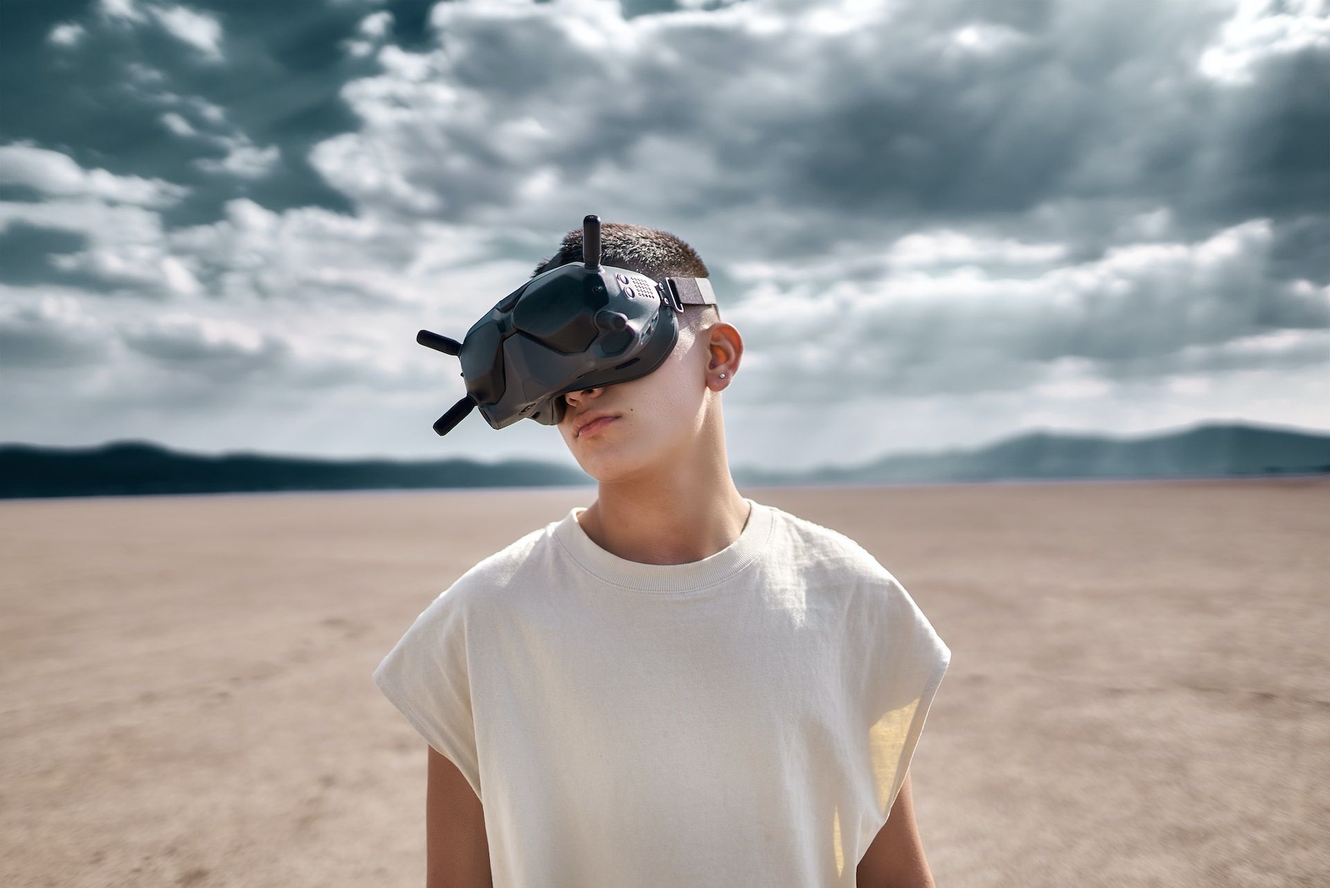 A young boy wearing a virtual reality headset in the desert.