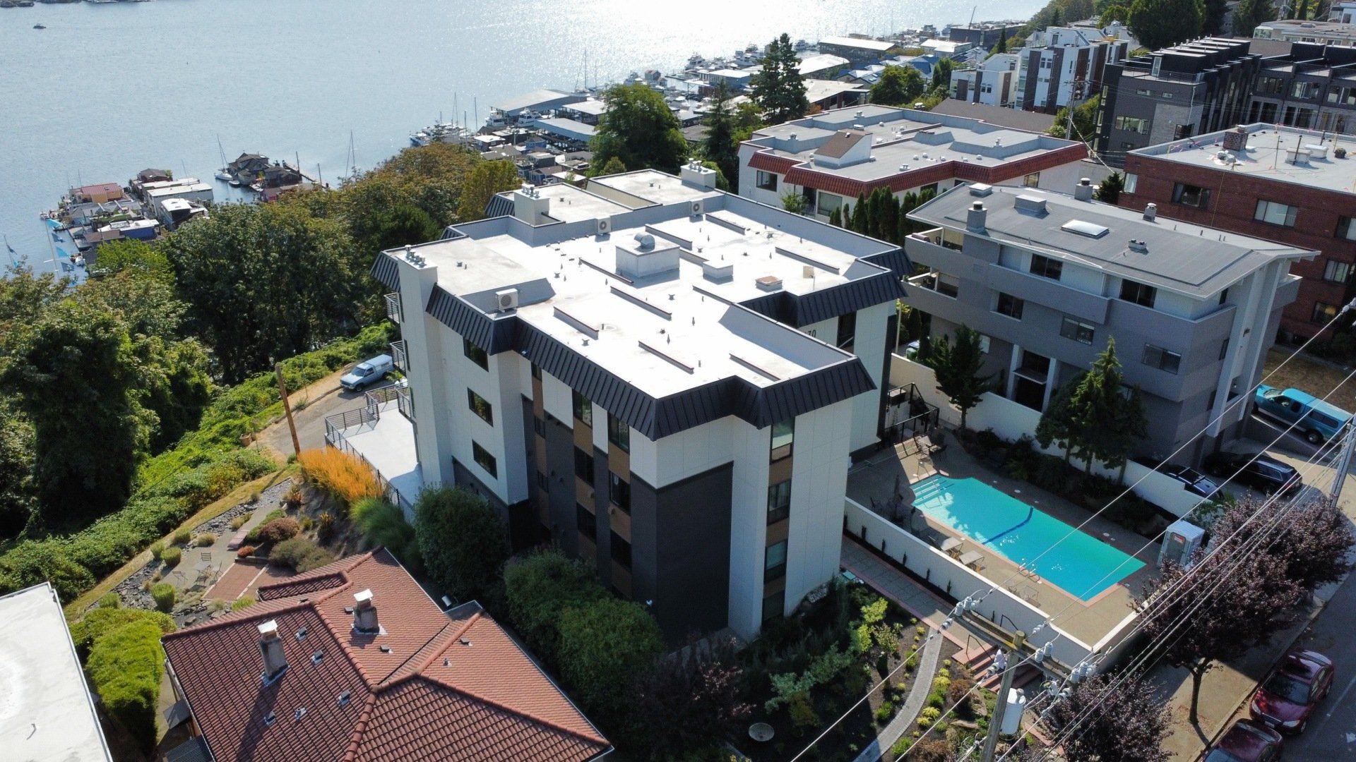An aerial view of a building with a pool in front of it