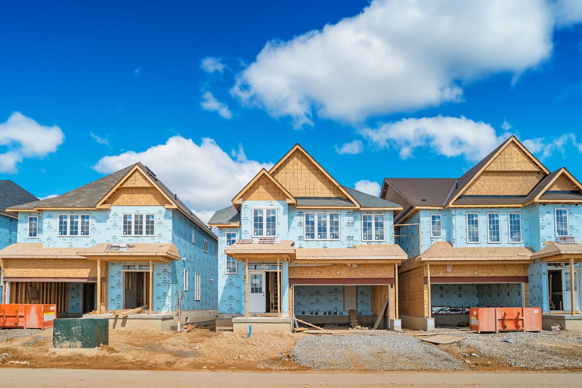 A row of houses are being built in a residential area.